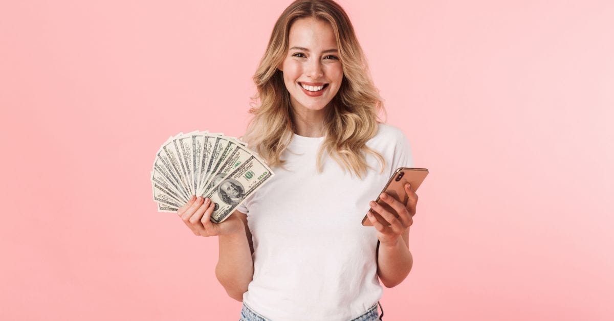 how to make money fast - pretty woman with handful of cash and her phone