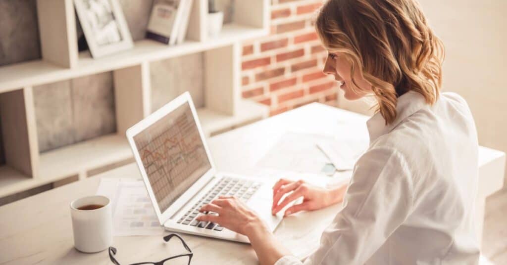 rank IQ review - smiling woman sitting at desk with laptop