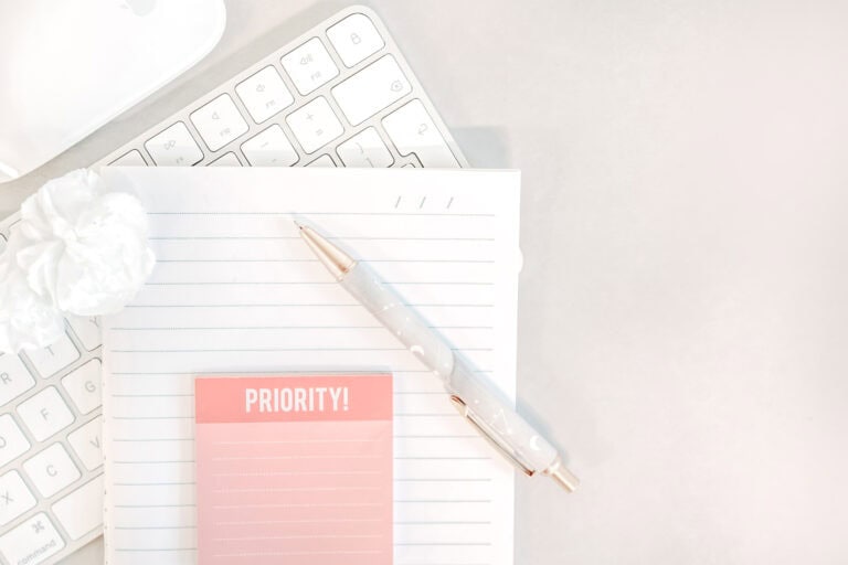 flatlay-priority-notebook-lined-notebook-white-keyboard-mouse-pen-flower-grey-background