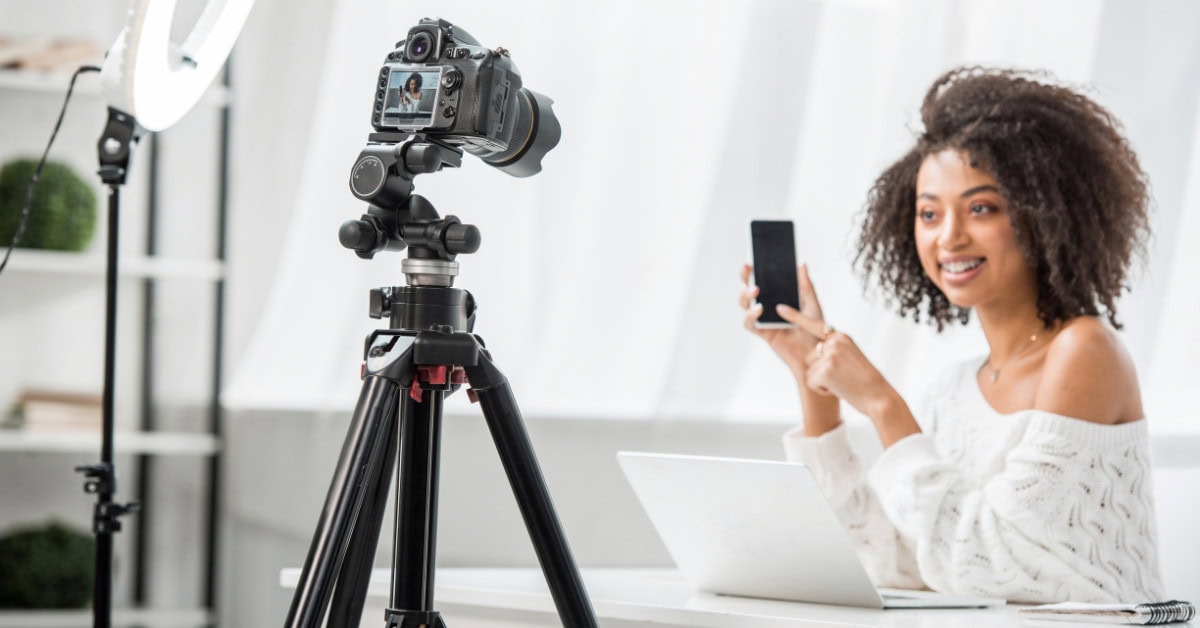 attractive woman with videocamera - freelance videographer hourly rate